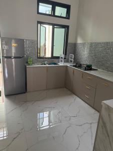 a kitchen with white marble floors and a refrigerator at d'house toraja in Rantepao