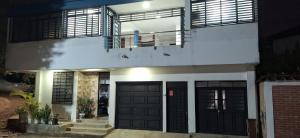 a house with black doors and a balcony at Nuevo y Confortable Apartamento in Florencia