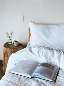 a book laying on top of a bed at Ahu Ahu Beach Villas in Oakura +22 photos