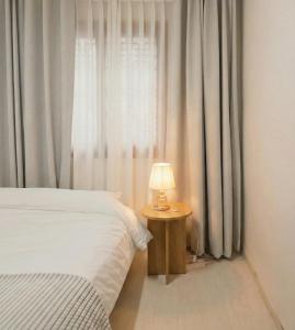 a bedroom with a bed and a table with a lamp at Stay EROB in Seoul