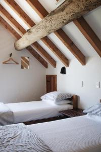 two beds in a room with wooden ceilings at Ahu Ahu Beach Villas in Oakura