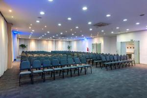 a conference room with blue chairs and a podium at Flat Premium Manaus no Adrianópolis in Manaus