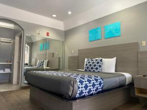 a bedroom with a large bed and a mirror at Island Suites Hobby Airport in Houston