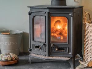a stove with a fire inside of it at Taliaris Isaf in Llandeilo