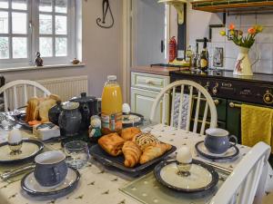 a kitchen table with croissants and bread on it at The Old Thatch in Hailsham +18 photos