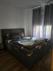 a large bed in a room with windows at Central Lux in Čačak