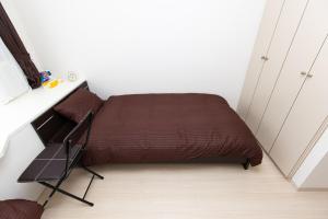 a small bedroom with a bed and a chair at アセット北初富 - 長期滞在歓迎 キッチン付きで一人旅やビジネス出張におすすめ 成田空港へ直通 in Kamagaya