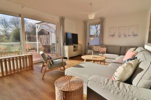 a living room with a couch and a table at Blüten & Meer - Haus Meer in Langeoog