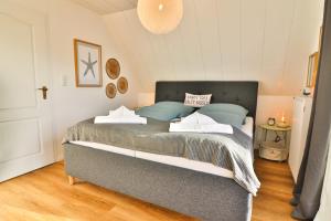 a bedroom with a large bed with blue pillows at Blüten & Meer - Haus Meer in Langeoog