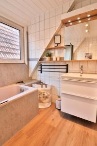 a bathroom with a tub and a sink and a bath tub at Blüten & Meer - Haus Meer in Langeoog +37 photos