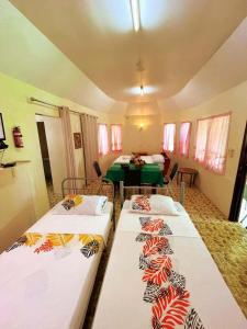 a room with two beds and a table in it at Talanoa Fales Accommodation in Apia