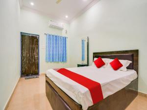 a bedroom with a large bed with red pillows at Hotel O Kanha in Nagpur