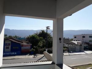 a view of a city street from a window at casa de praia grande e espaçosa in Bertioga