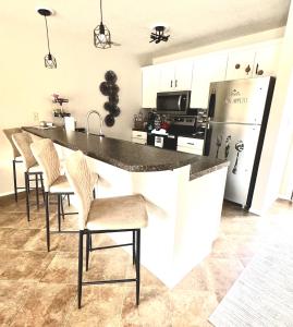 a kitchen with a counter with chairs and a refrigerator at Lakefront Condo Private Deck 3 Pools in Osage Beach