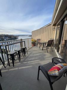 a balcony with chairs and tables on a building at Lakefront Condo Private Deck 3 Pools in Osage Beach