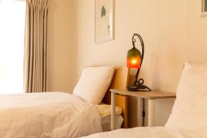 a bedroom with two beds and a lamp on a table at inn 1st in Yakage
