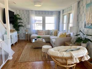 a living room with a couch and a table at Nautical Endeavors Beach House Steps from Surf in Rodanthe
