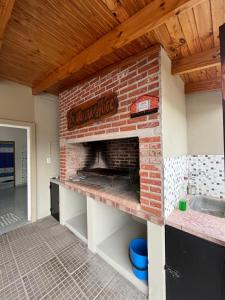 a kitchen with a brick fireplace in a kitchen at La Matera de Hugo in Lobos