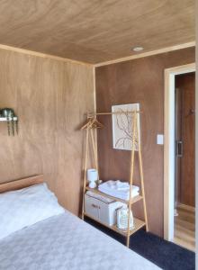 a bedroom with a bed and a shelf with aperature at Tide and Tranquility - Guest Studio in Snells Beach