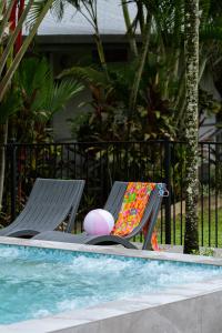 two chairs sitting next to a swimming pool with a ball at Tasman Holiday Parks - Cairns Cool Waters in Cairns +88 photos