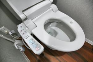 a white toilet with a remote control next to it at QU302 EPrivate 2BR Home with Living Room and Kitchen, Separate Bath and Toilet, Sleeps 4 in Tokyo