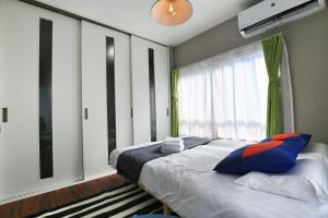 a bedroom with a large bed and a window at QU302 EPrivate 2BR Home with Living Room and Kitchen, Separate Bath and Toilet, Sleeps 4 in Tokyo +18 photos