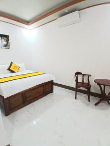 a bed and a chair in a room at Nhi Quỳnh La Gi Hotel in Lagi +17 photos