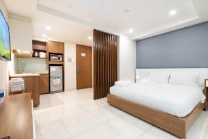 a bedroom with a large bed and a kitchen at Jade House Tran Cao Van in Ho Chi Minh City