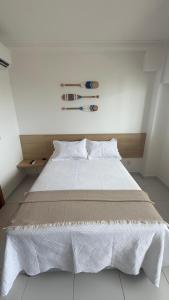 a bedroom with a large bed with white sheets at Flat Inteiro no Makia Beach Experience in Porto De Galinhas +18 photos