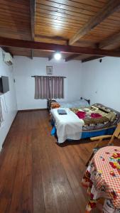 a room with a large bed and a wooden floor at La Reina in Eldorado
