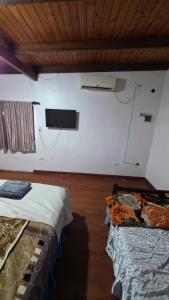 a room with two beds and a tv on the wall at La Reina in Eldorado