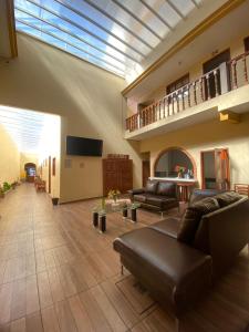 a large living room with a couch and a tv at Hotel Jocari in Cholula