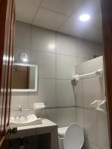 a bathroom with a toilet and a sink and a mirror at Hotel Jocari in Cholula