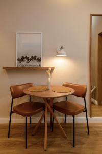a table with two chairs and a table with a vase at Studio Quarto e Sala Moderno em Ipanema, próximo a praia in Rio de Janeiro