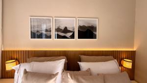 a bedroom with three pictures on the wall at Studio Quarto e Sala Moderno em Ipanema, próximo a praia in Rio de Janeiro