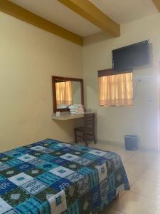 a bedroom with a bed and a table and a mirror at Hotel Jocari in Cholula
