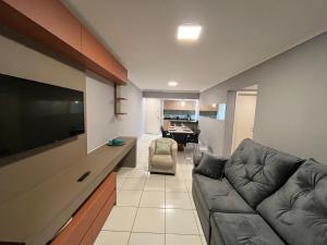 a living room with a couch and a flat screen tv at Apto 33 - Completo no Centro de Foz in Foz do Iguaçu