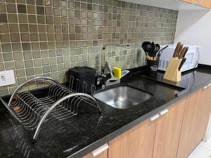a kitchen counter with a sink in a kitchen at Apto 33 - Completo no Centro de Foz in Foz do Iguaçu +24 photos