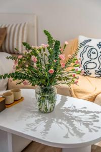 a vase filled with pink flowers on a table at Aimee House Vũ Miên in Hanoi +29 photos