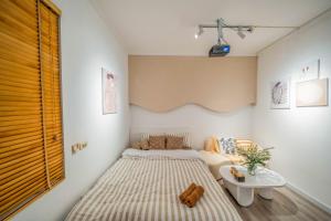 a small bedroom with a bed and a table at Aimee House Vũ Miên in Hanoi