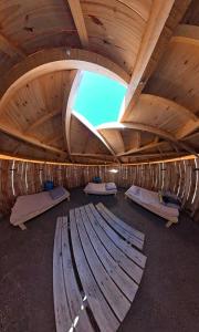 a large room with several beds and a wooden ceiling at Yurtas Patagónicas Refugio de estepa in Bajo Caracoles