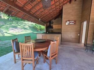a wooden table and chairs on a patio at Sitio Mangalarga in Araras Petropolis