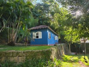 a blue house in the middle of a yard at Sitio Mangalarga in Araras Petropolis