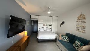 a living room with a bed and a couch at Rêve Marina studio tout confort avec citerne et piscine Gosier in Pointe-à-Pitre