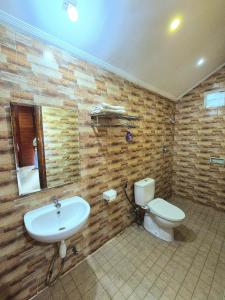 a bathroom with a sink and a toilet at Baron Ndut's Cottage in Mantaak