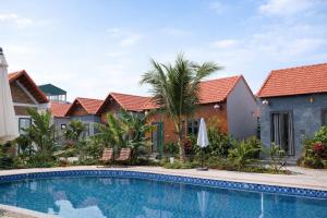 a villa with a swimming pool in a resort at Senna Garden Homestay in Xuân Sơn
