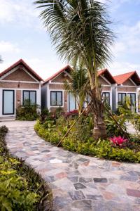 a house with a palm tree in front of it at Senna Garden Homestay in Xuân Sơn
