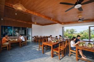 a group of people sitting at tables in a restaurant at Senna Garden Homestay in Xuân Sơn