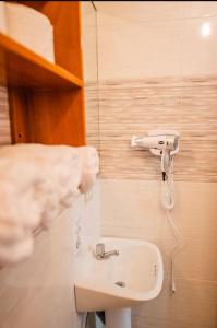 a bathroom with a sink and a phone on the wall at Suites en el Centro in Puerto Ayora