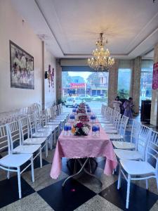 a long table with white chairs and a christmas tree on it at Thanh Binh Hotel in Hà Tĩnh